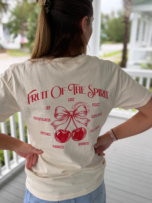 Back of a cream Christian graphic tee featuring a distressed red “Fruit of the Spirit” design with cherries tied in a bow and the fruits of the Spirit from Galatians 5:22–23.